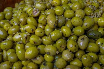 Un tas d'olives vertes marinées avec des herbes et de l'ail, probablement de Cotignac, France
