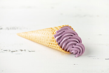 Vanilla berry soft ice cream in a  in waffle cone on a white background