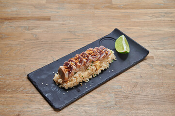 A plate of food with rice and meat on it. There is a lime on the plate