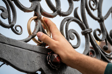 Nuremberg, Germany, August 2, 2023. Detail shot of the fountain in the market square. The golden ring embedded in the railing is considered a lucky charm if rotated. The hand rotates it.