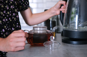 Little Girl Brewing A Black Tea In Teapot