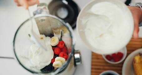 Fruit smoothie, hands and yogurt in blender for breakfast shake, meal replacement and healthy nutrition. Above, machine and preparation in kitchen for weight loss beverage, person diet and wellness