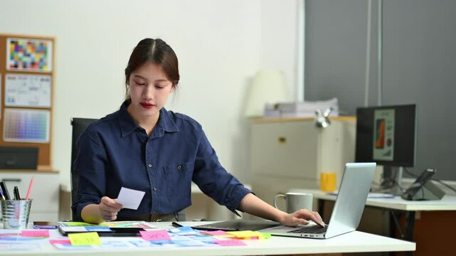 UX UI designer planning mobile layout with sticky notes in modern office. Creative brainstorming and prototyping workflow