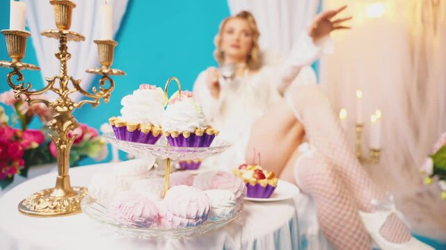 blurred silhouette woman queen sitting at dinner table drinking hot tea dessert cakes pies marshmallows sweet confectionery. Fantasy Girl princess having breakfast Victorian style room, vintage dress