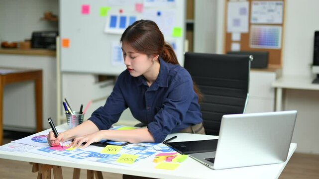 UX UI designer drawing app wireframe with pencil and color palette. Creative workspace with sticky notes and tablet. Ideal for prototyping