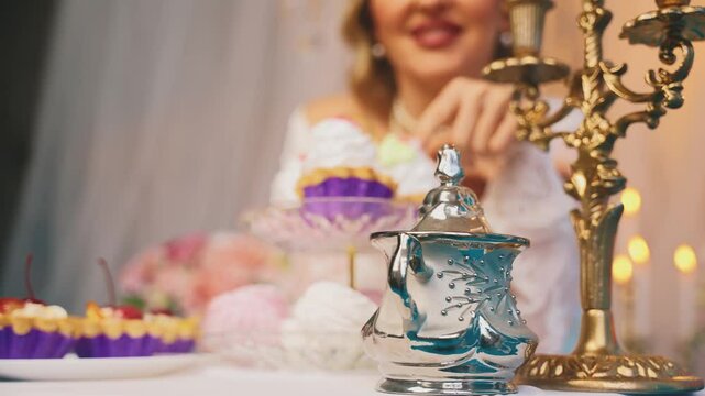 blurred silhouette happy smiling face lips woman queen sitting at dinner table drinking hot tea dessert cakes pies sweet confectionery. Fantasy Girl princess having breakfast Victorian style room 4k.
