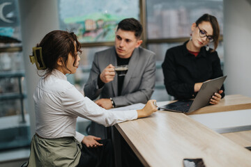 Three business professionals engaged in a focused discussion during a meeting. The scene captures a collaborative working environment, emphasizing teamwork, communication, and professional attire in