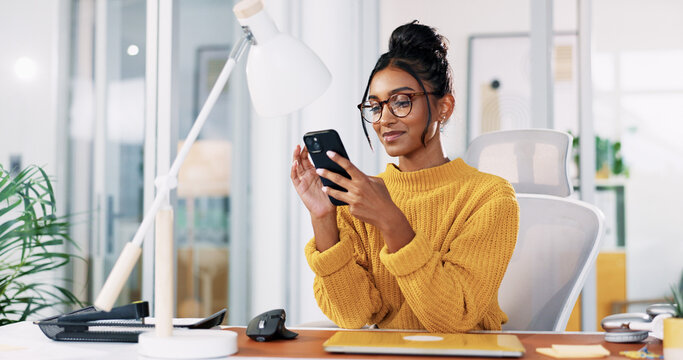 Office, Indian woman and glasses with smartphone for reading, blog post and online communication. Smile, business person and journalist on break with mobile, news application and chat on social media