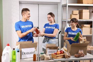 Volunteers packing food donations at tables indoors