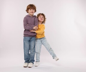 Cute little brothers hugging on white background