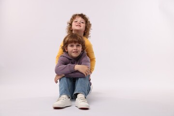 Cute little brothers posing on white background