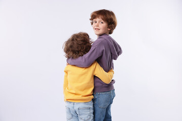Cute little brothers hugging on white background