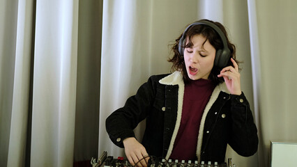 A cheerful girl interacts with audio equipment, singing and smiling as she adjusts the controls. The image reflects creativity, dynamic energy, and a love for sound.