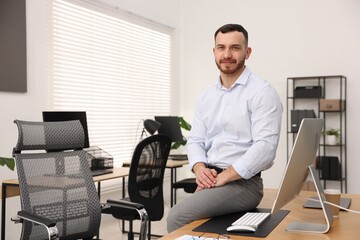 Portrait of handsome businessman at workplace in office. Space for text