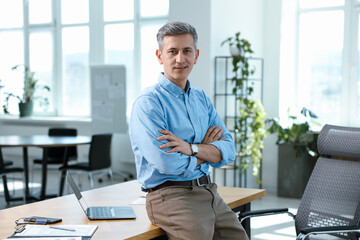 Portrait of businessman with crossed arms at his workplace