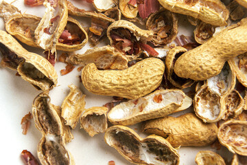 Scattered peanut leftovers. Nut shells on a dinner plate. Macro. 