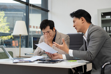 Serious male businessman concentrat on his paper work at the table at office.