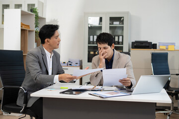 Serious male businessman concentrat on his paper work at the table at office.