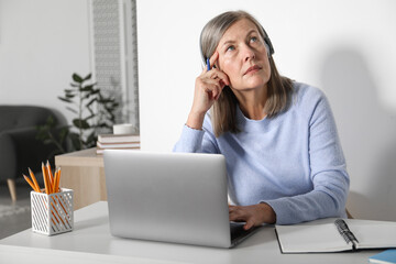 Woman learning online using laptop at table indoors. Self-study