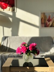 Beautiful pink peonies in vase on table at home. Interior design. 