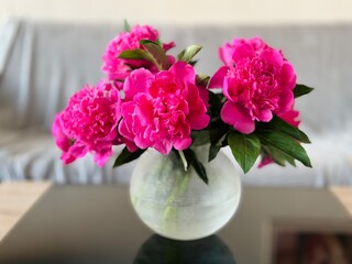 Beautiful pink peonies in vase on table at home. Interior design. 