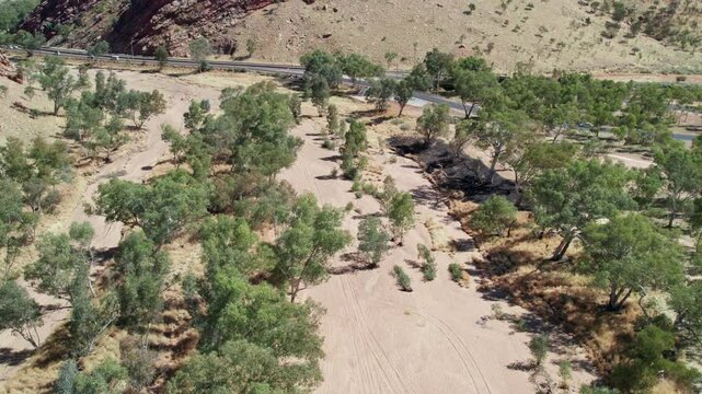 Aerial view of the dry Todd River in the full sunat it enters Heavitree Gap. Alice Springs, Mparntwe, Northern Territory, Australia. August 2022.