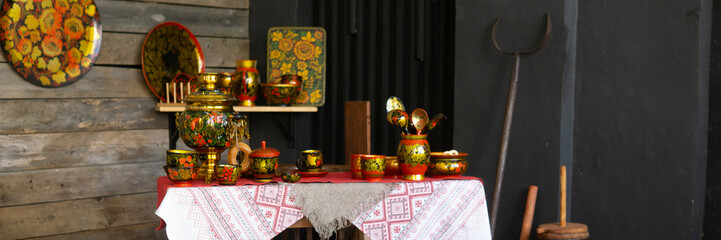 Traditional russian table setting with khokhloma decorated dishes, samovar, and embroidered tablecloth, reflecting russian folk art and culture.