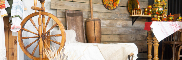Traditional Russian spinning wheel and samovar. Interior with folk crafts and rustic objects....