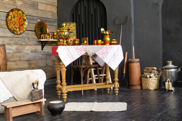 A table is set with traditional russian khokhloma painted teaware including a samovar, cups, and spoons. Russian folk art and culture concept for decoration.