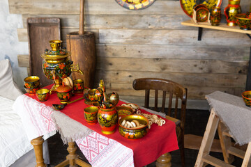 Traditional Khokhloma folk craft table setting with samovar, spoons, and snacks. Russian tea drinking food and decorative tableware for cultural design background.