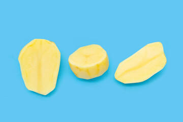 Raw peeled potatoes on blue background
