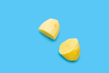 Raw peeled potatoes on blue background
