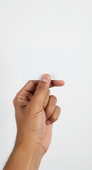 Hand holding a plain brochure or flyer with no branding or writing, photographed inside a professional photo studio on a pure white background 