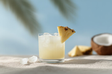 refreshing cocktail with pineapple and coconut served on sandy beach surrounded by bright tropical fruits and ice