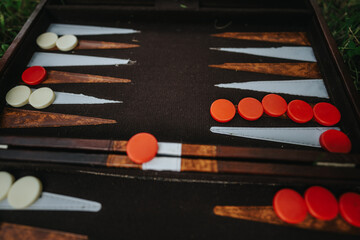 Detailed close-up of a backgammon board showcasing strategic positioning of red and white pieces, highlighting the classic game's elements.