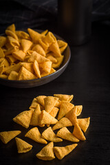 Salted snack chips on black table.