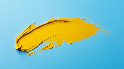 Yellow paint stroke on a light blue background creating an abstract artistic expression image