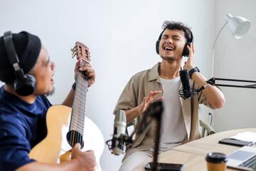 Men with Microphone Singing and Playing Guitar in Podcast Studio