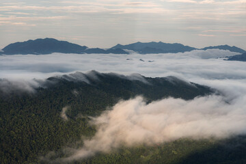 Morning fog and clouds descending over the mountain peaks and into the valley of remote parts of northern Vietnam