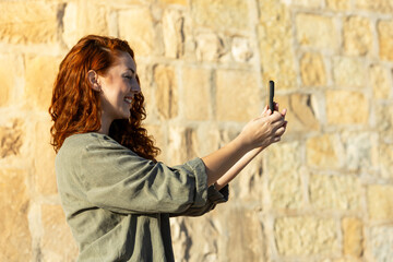 Woman smiling while holding smartphone for selfie call. Lifestyle. Technology.