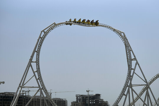 A roller coaster reaches the peak of a loop against a clear blue sky.  Abu Dhabi, UAE