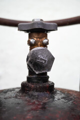 Close-up of an old metal gas cylinder valve. Industrial texture with visible rust, wear, and signs...
