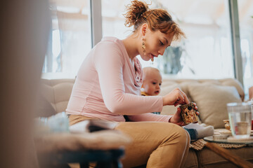 A mother and her baby indoors, enjoying bonding time in a cozy living room. The scene depicts...