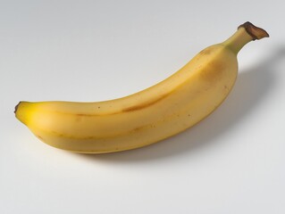 A single ripe banana placed diagonally on a clean white surface, captured from a top-down flat lay angle. 