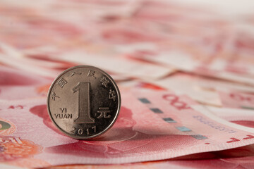 Single Chinese coin stands upright over banknote. Close up. © svetlana_cherruty