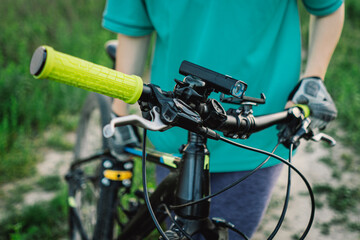 A close-up image of a womans hand gripping the handlebars of a mountain bike.