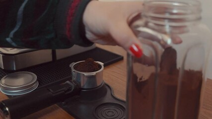 A barista locks a stainless-steel portafilter filled with freshly ground espresso into a dosing collar mounted on a wooden countertop. The dosing station provides precise tamp alignment and excess - Powered by Adobe