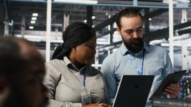 Server hub supervisor overseeing computer scientists improving neural network algorithms. Data center manager reviewing performance of employees doing checkup on infrastructure, camera A