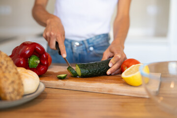 Young woman preparing fresh vegetables and fruits in a modern kitchen. Concept of clean eating, wellness, natural lifestyle, and healthy food preparation.