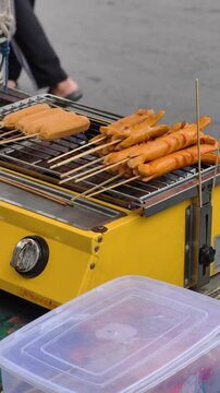 Grilled sausages Bockwurst on barbecue grill grate. Grilled sausage with skewers